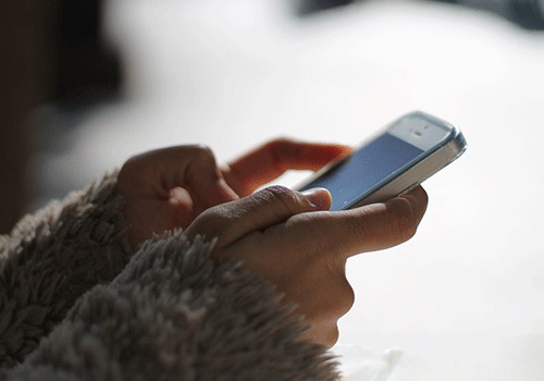 mão de jovem digitando e vendo mensagens de outro celular